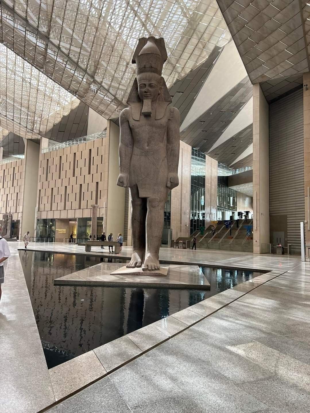 Egyptologist presenting King Tutankhamun’s treasures to visitors inside Cairo’s Grand Egyptian...