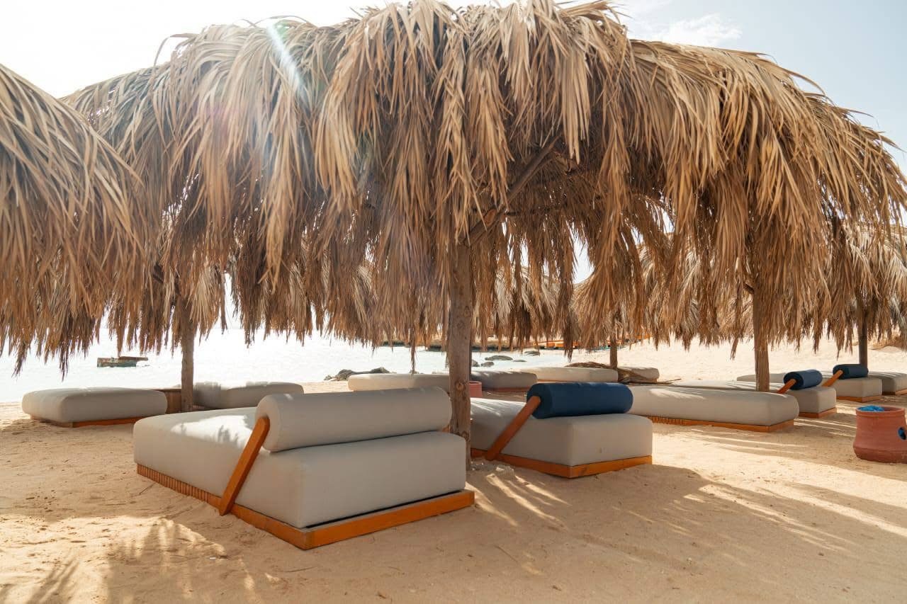 Underwater image of snorkelers exploring colorful coral gardens near Ozirea Island Hurghada with visible reef fish and excellent water clarity; emphasizes marine life, visibility and family‑friendly reef access.