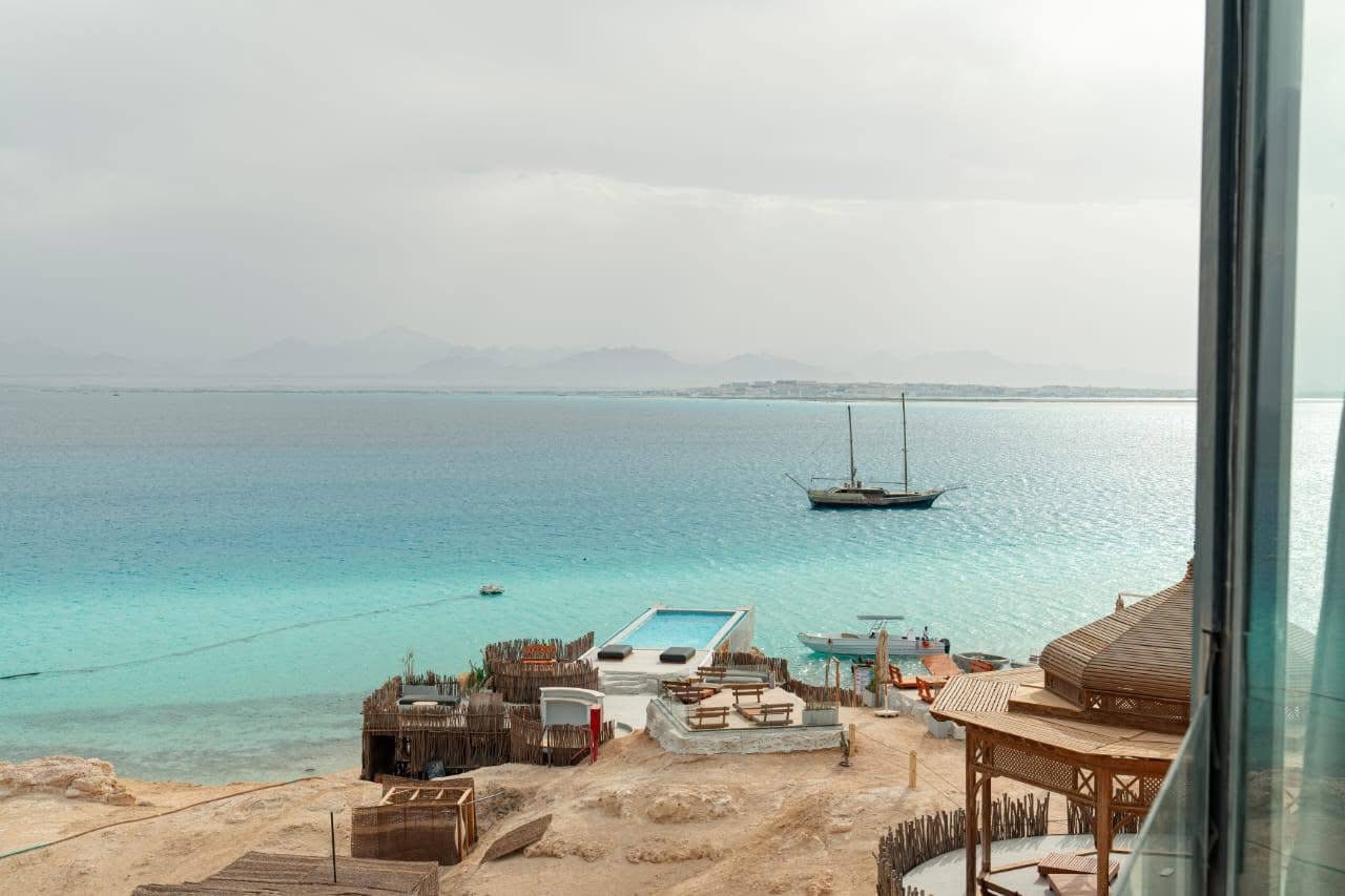 Description (SEO‑optimized): Wide hero shot of Ozirea Island Hurghada showing the infinity‑style pool, designer sunbeds and turquoise sea; highlights the island’s luxury setting and panoramic views to attract clicks and social shares.