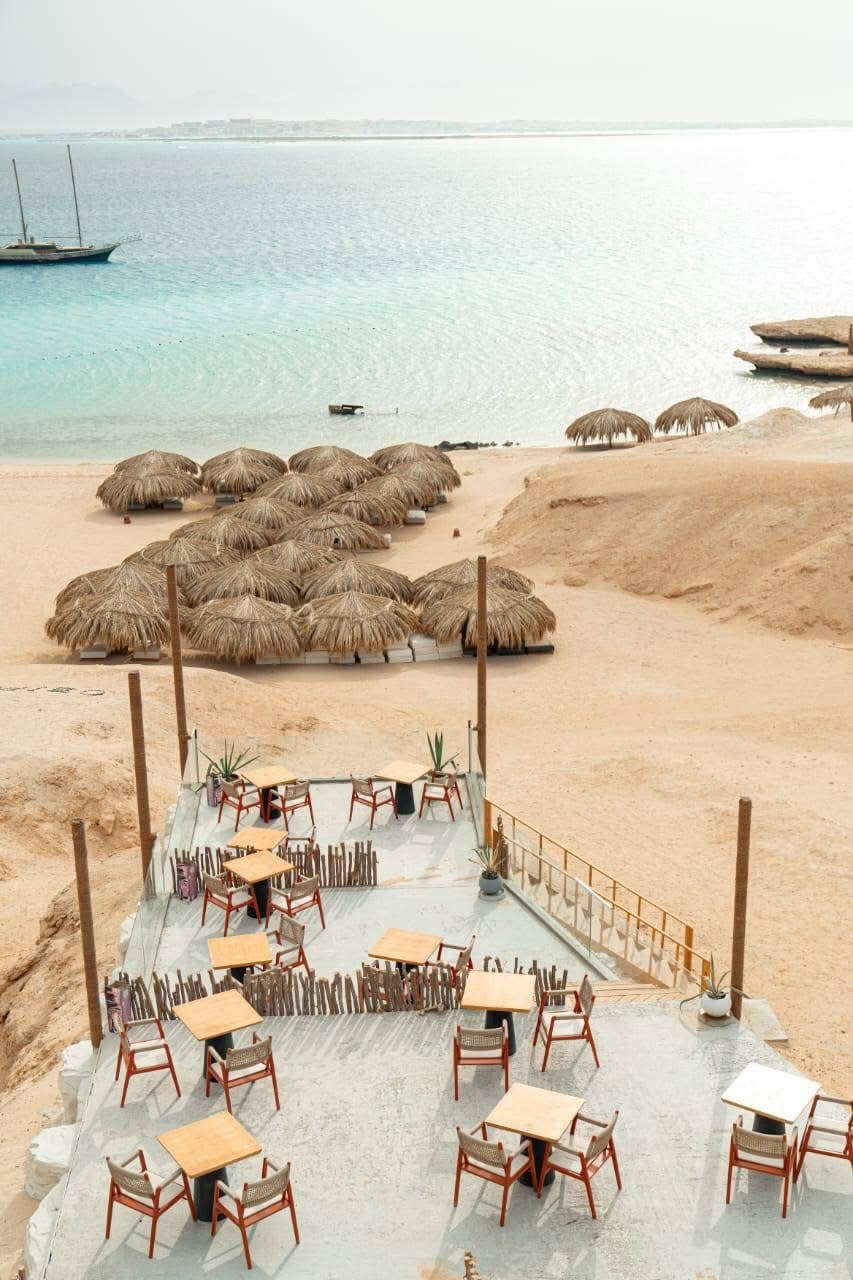 Underwater image of snorkelers exploring colorful coral gardens near Ozirea Island Hurghada with visible reef fish and excellent water clarity; emphasizes marine life, visibility and family‑friendly reef access.