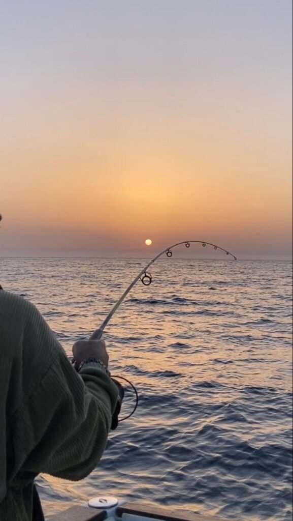Fishing boat heading out to deep sea from Hurghada marina early morning Red Sea fishing trip 2026